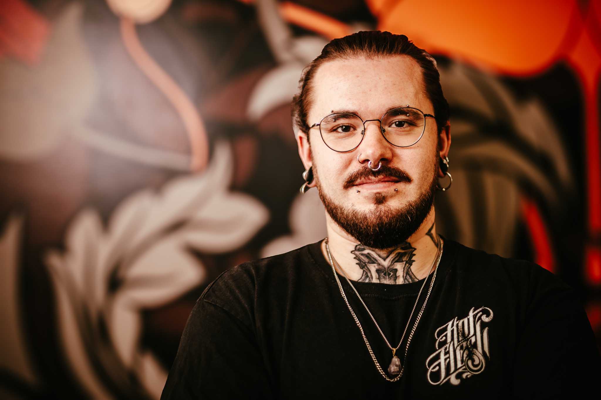 Domi vor der schwarz-orangefarbenen Studiowand